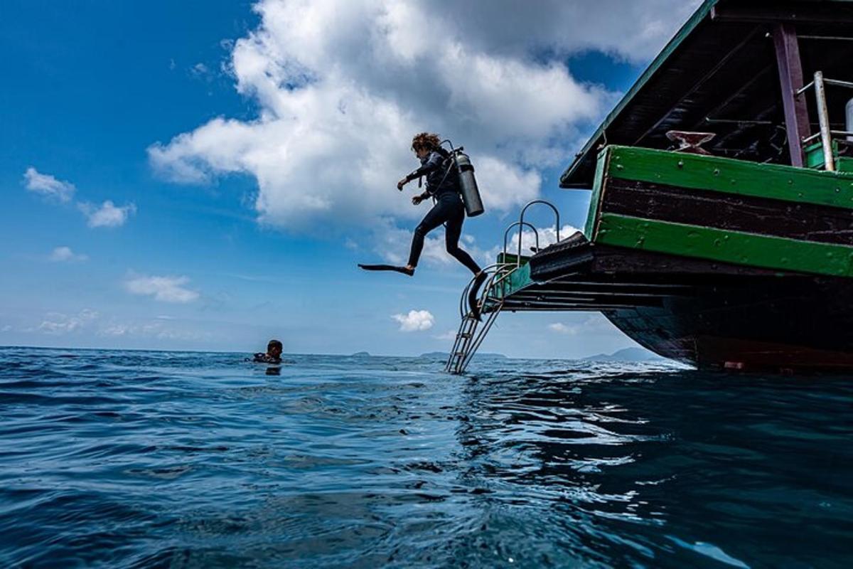 uma pessoa pulando de um barco na água