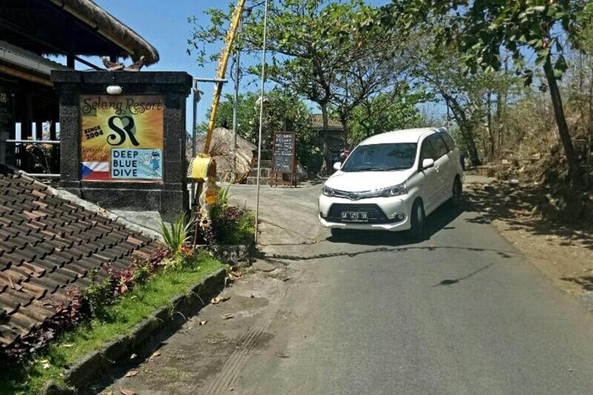 bílé auto zaparkované na kraji silnice
