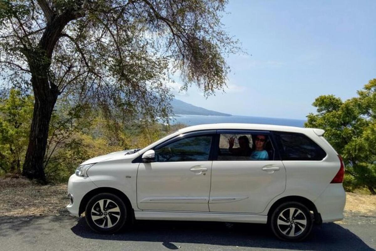 bílé auto zaparkované na kraji silnice