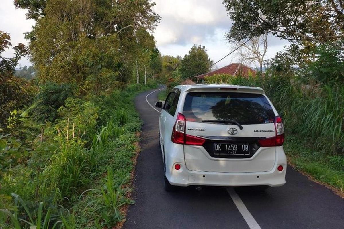 bílé auto zaparkované na kraji silnice