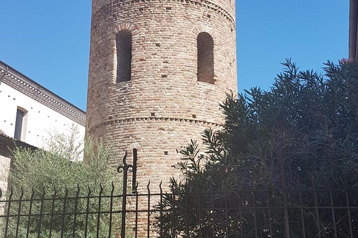 una torre de maó amb dues finestres darrere d'una tanca