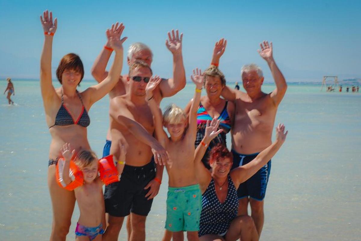 un gruppo di persone in posa per una foto sulla spiaggia