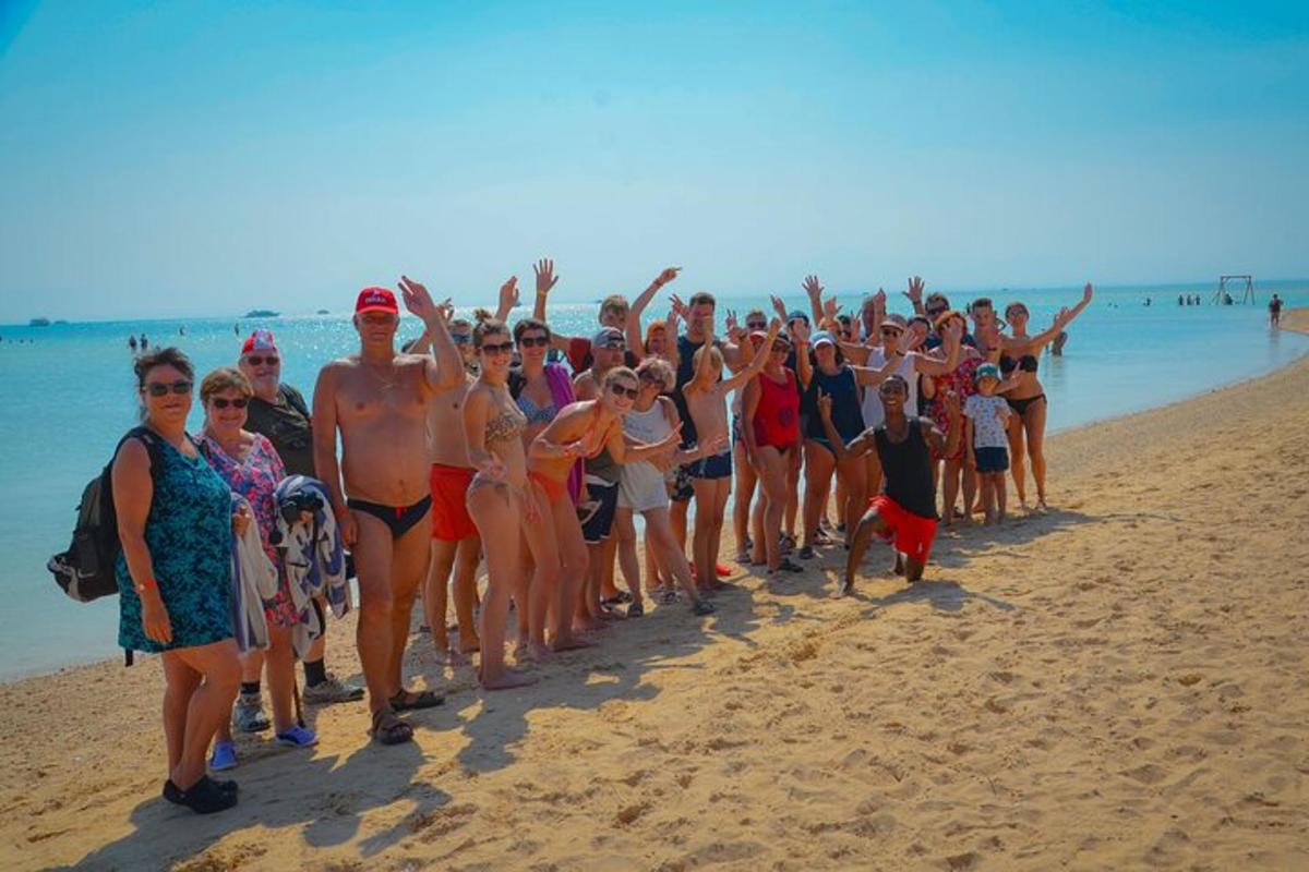 un folto gruppo di persone in piedi sulla spiaggia