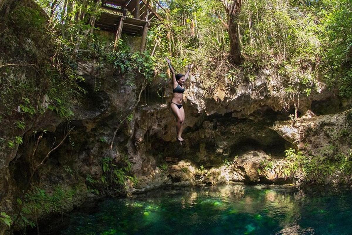 a woman jumping off a cliff into a pool of water