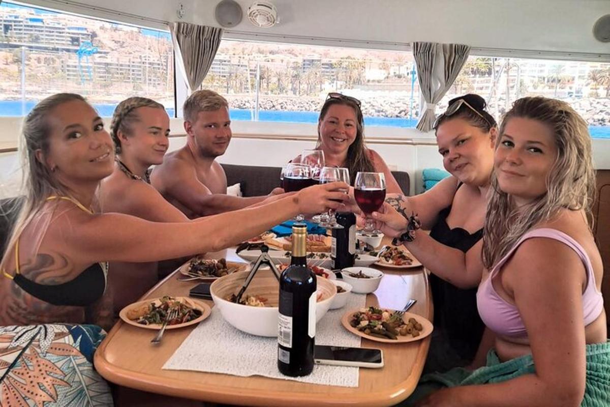 Un grupo de personas sentadas en una mesa con copas de vino.