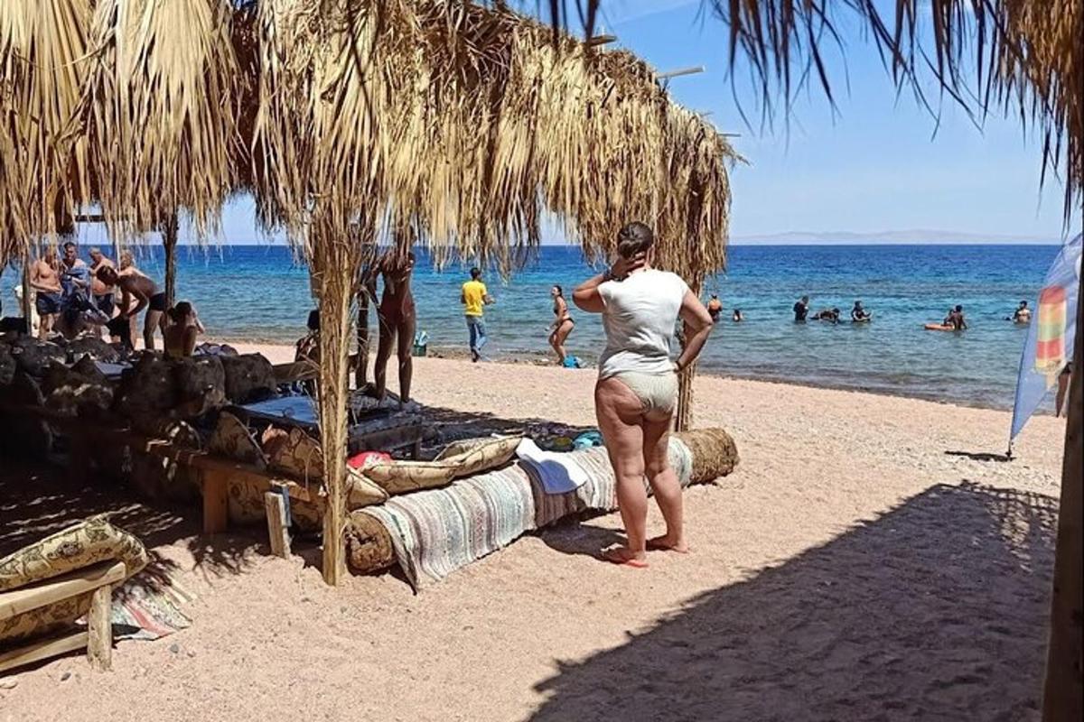 seorang wanita berdiri di pantai berhampiran air