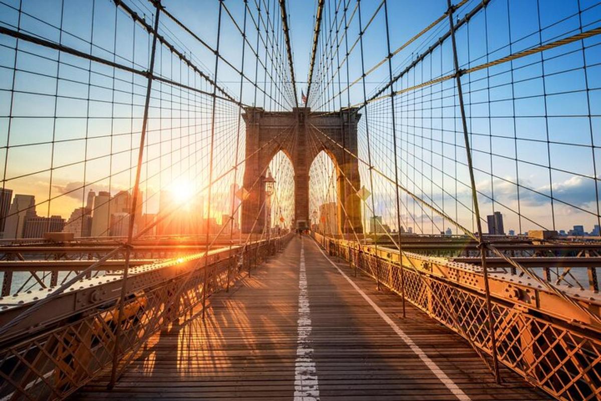 a bridge with the sun setting over a city