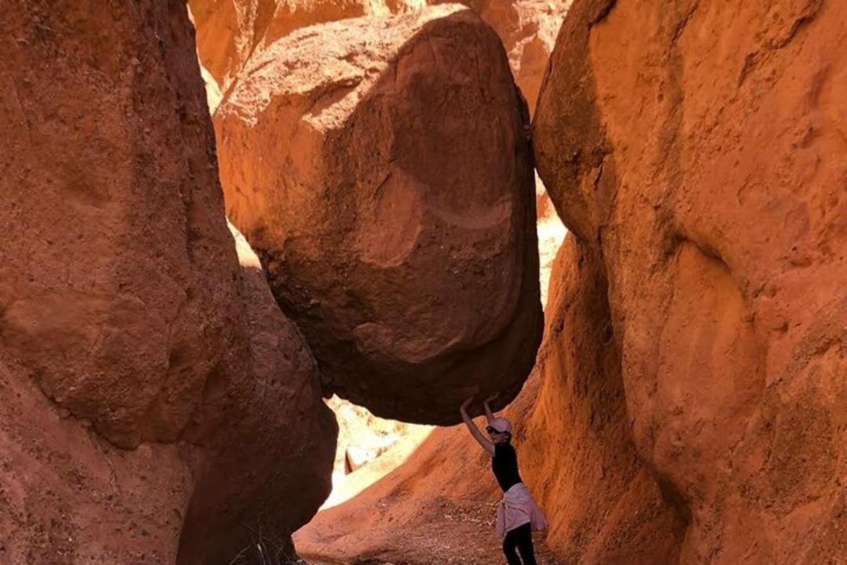 a person hanging from a rock in a canyon