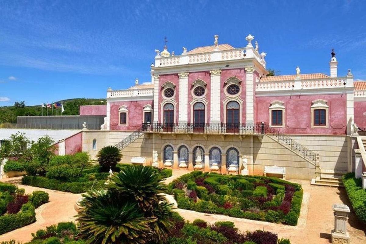 a pink building with a garden in front of it