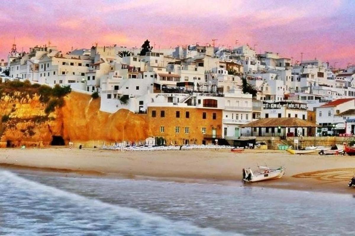 a beach with a group of white buildings and a town