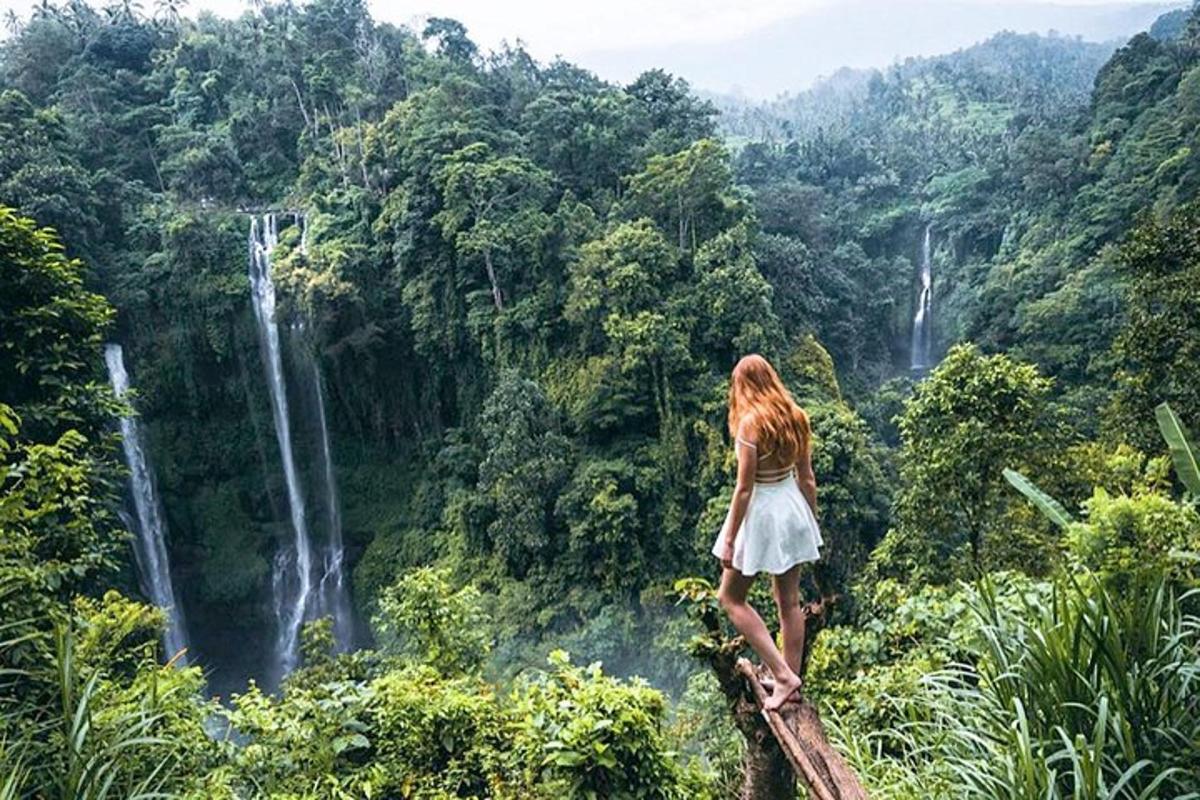 uma mulher parada em uma ponte olhando para uma cachoeira
