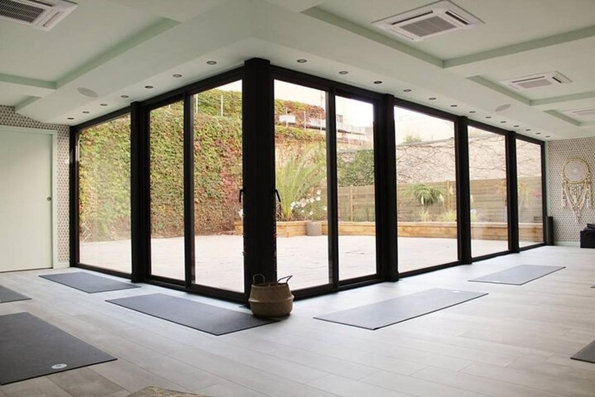 a room with a large glass door with yoga mats