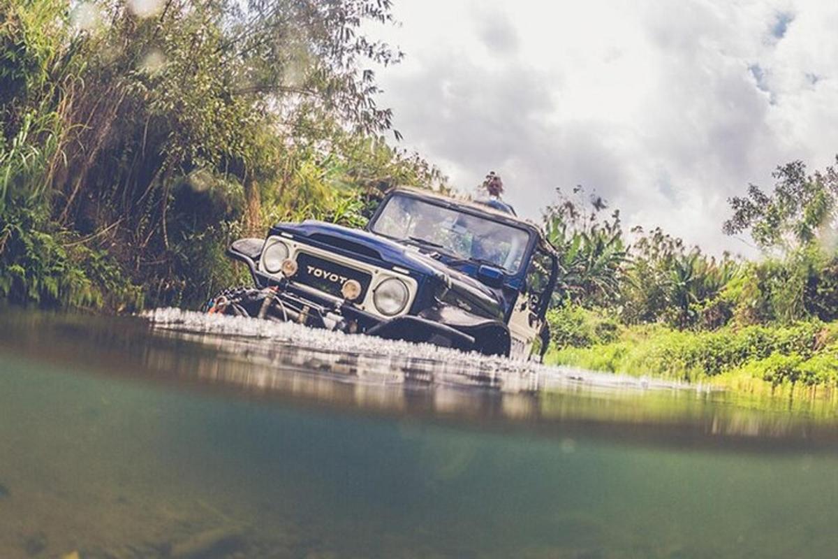 Un coche viejo circulando por un cuerpo de agua