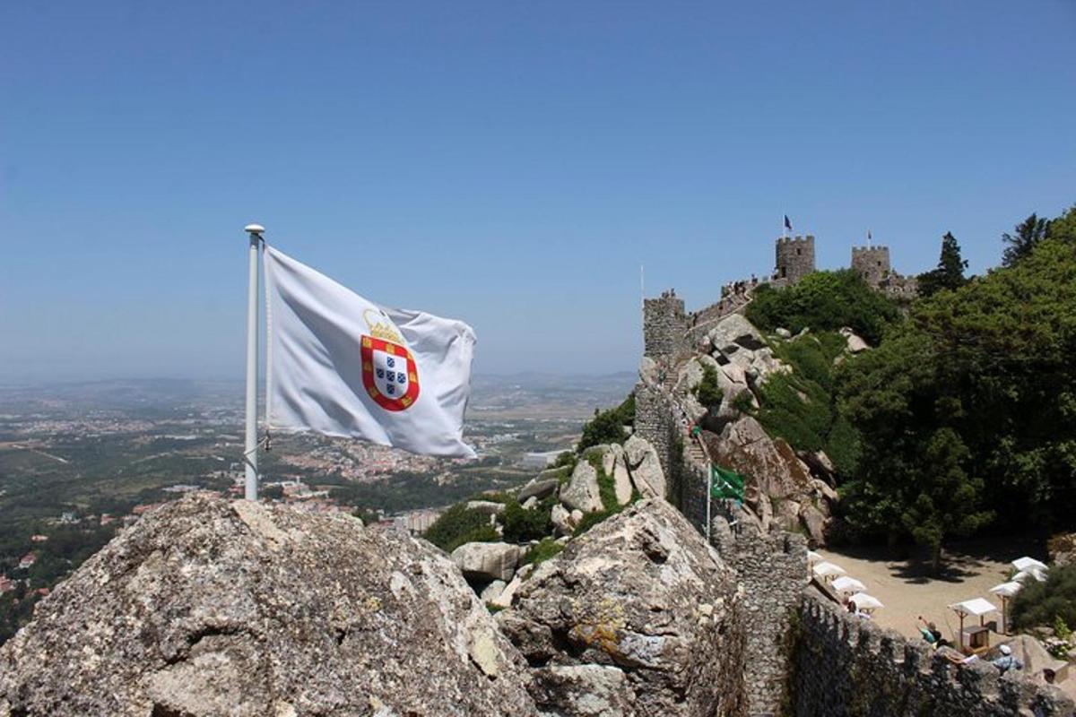 a flag on top of a mountain with a castle