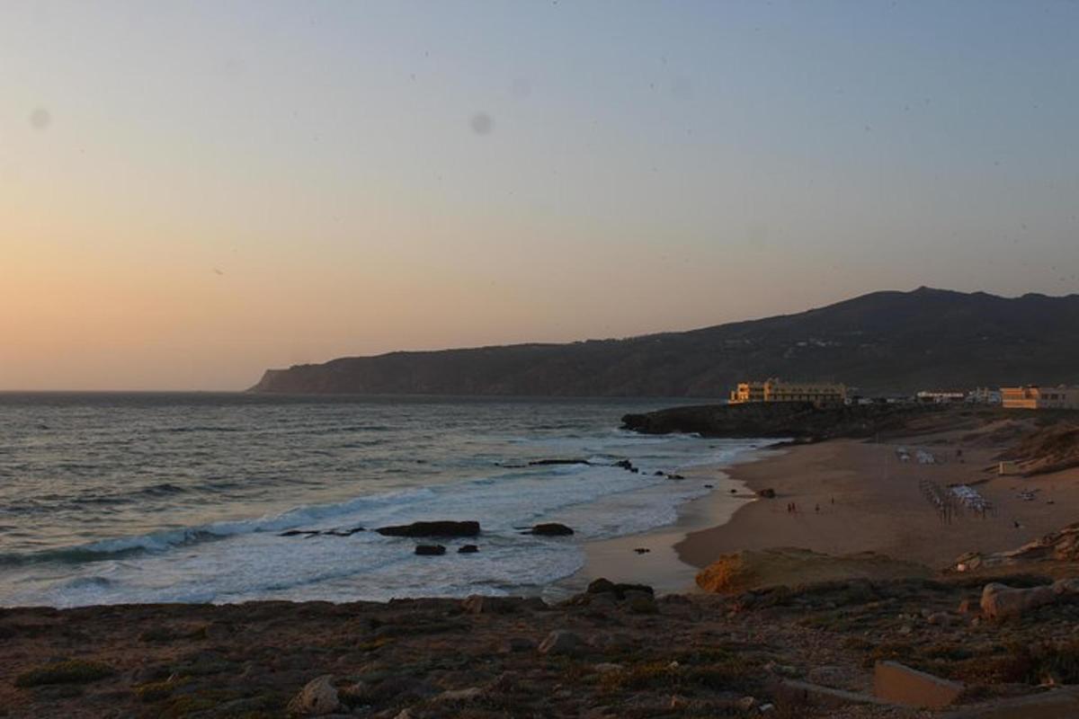 una spiaggia con l'oceano e le montagne sullo sfondo