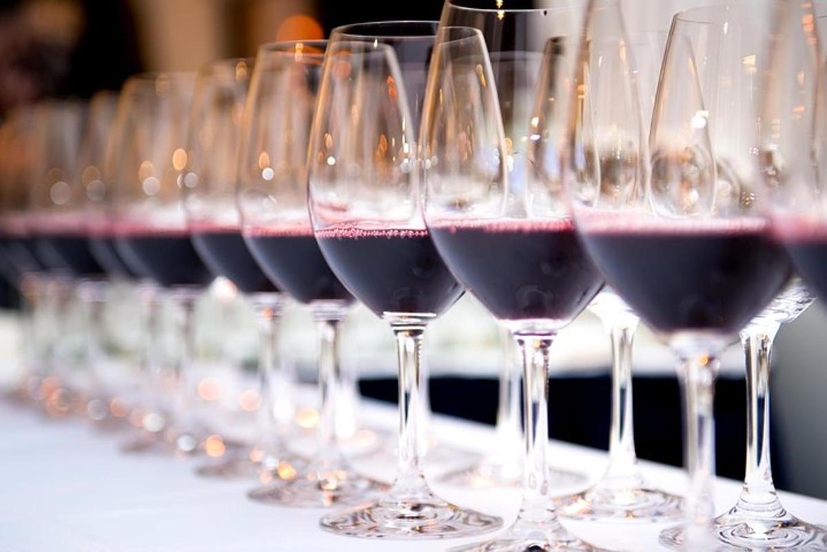 una fila di bicchieri da vino pieni di vino rosso