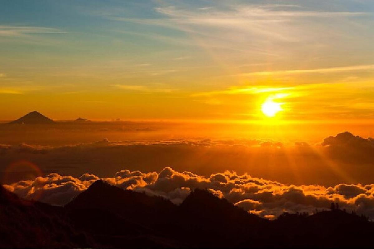 a sunset above the clouds over the mountains