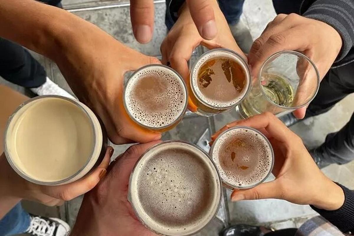un grup de oameni care își țin în sus paharele de bere