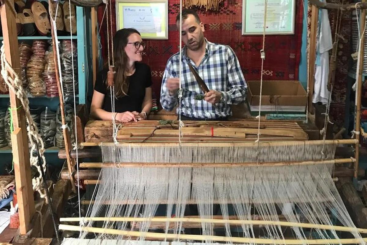 a man and a woman standing in front of a weaving machine