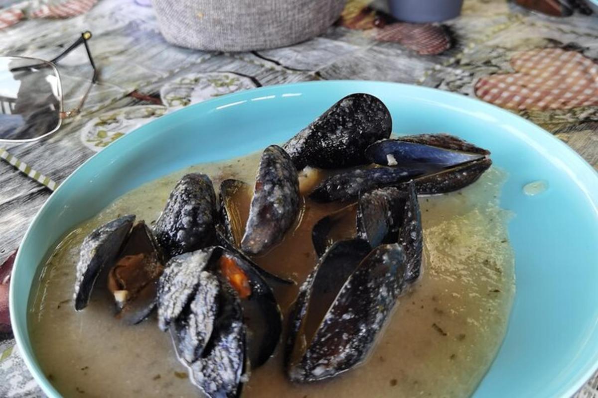 Un tazón de comida con mejillones en una mesa.