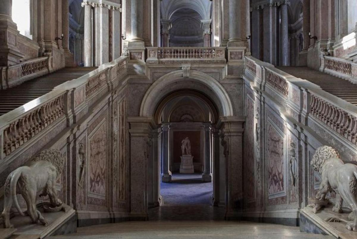 a hallway in a building with statues on the stairs