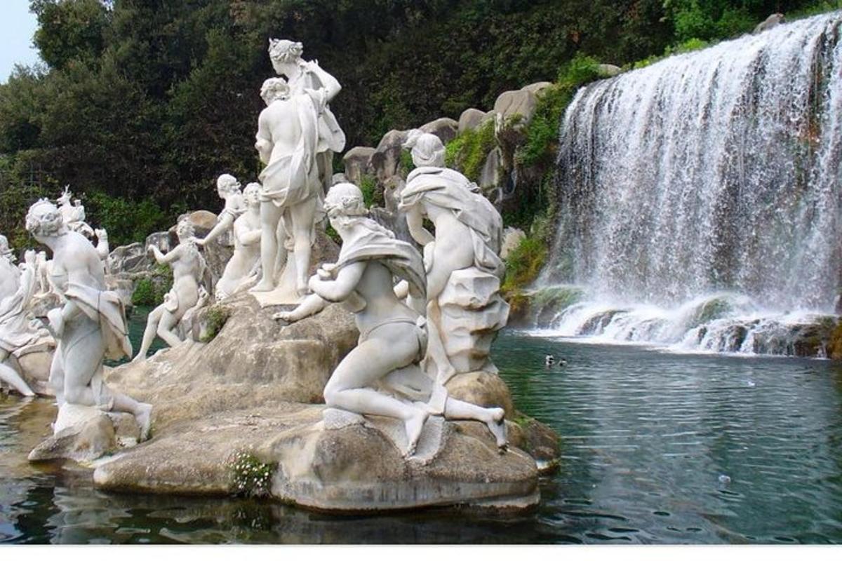 uma estátua de pessoas em frente a uma cachoeira