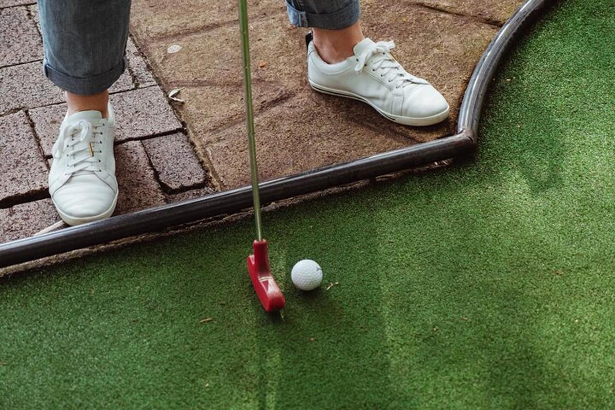 osoba v bílých botách hrající golf