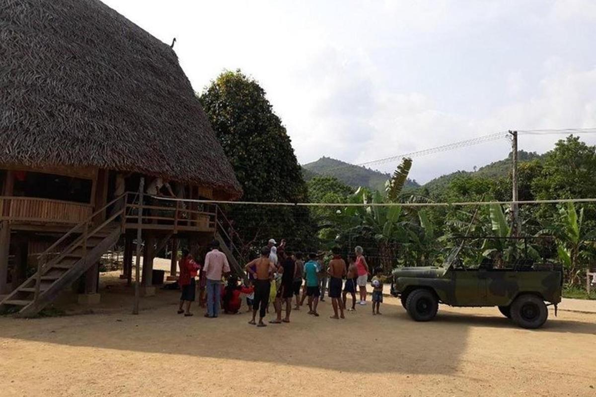 um grupo de pessoas em pé do lado de fora de um prédio com um caminhão militar