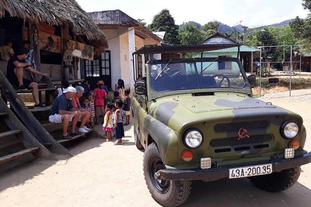 um caminhão do exército estacionado na frente de um grupo de pessoas