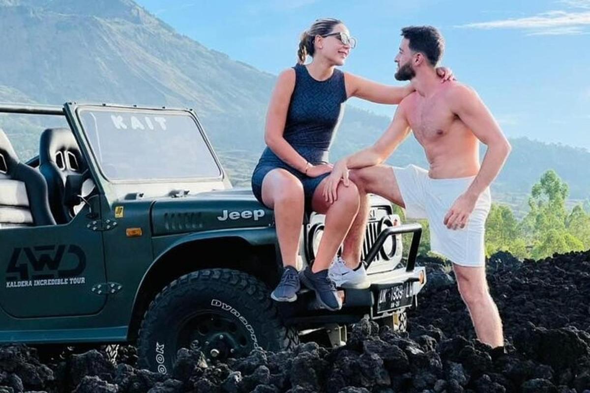 Un hombre y una mujer sentados en la parte trasera de un jeep