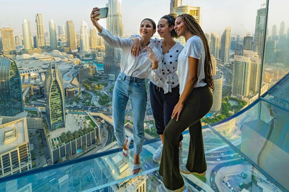three girls taking a picture on top of a skyscraper