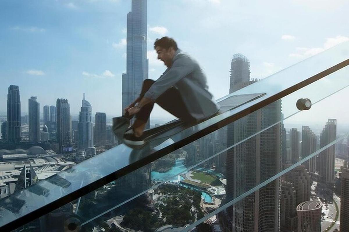 a man sitting on the edge of a glass building