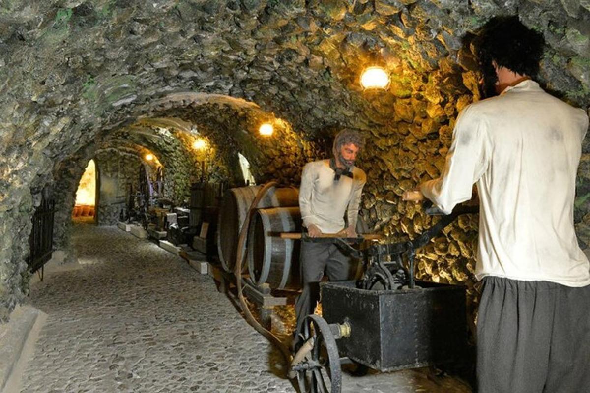doi bărbați stând într-un tunel de piatră cu un bărbat pe bicicletă