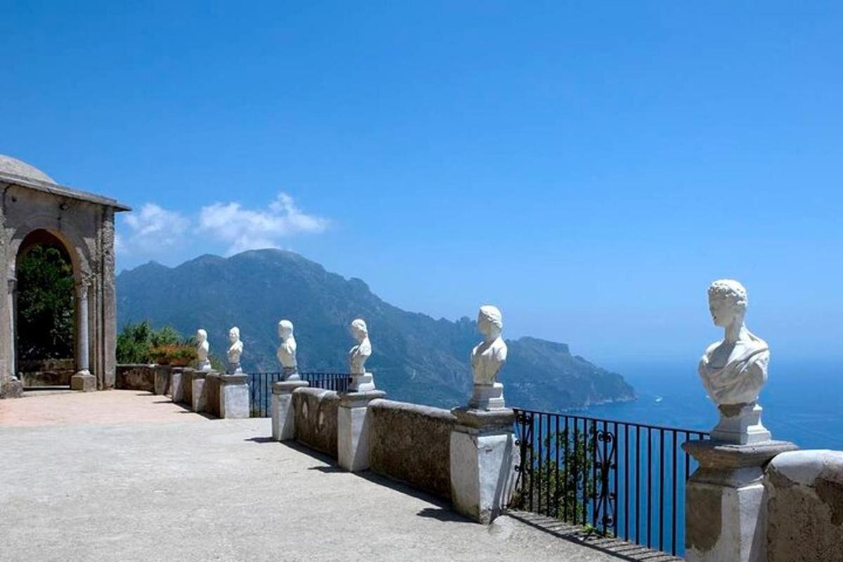 a row of statues on a fence overlooking the ocean