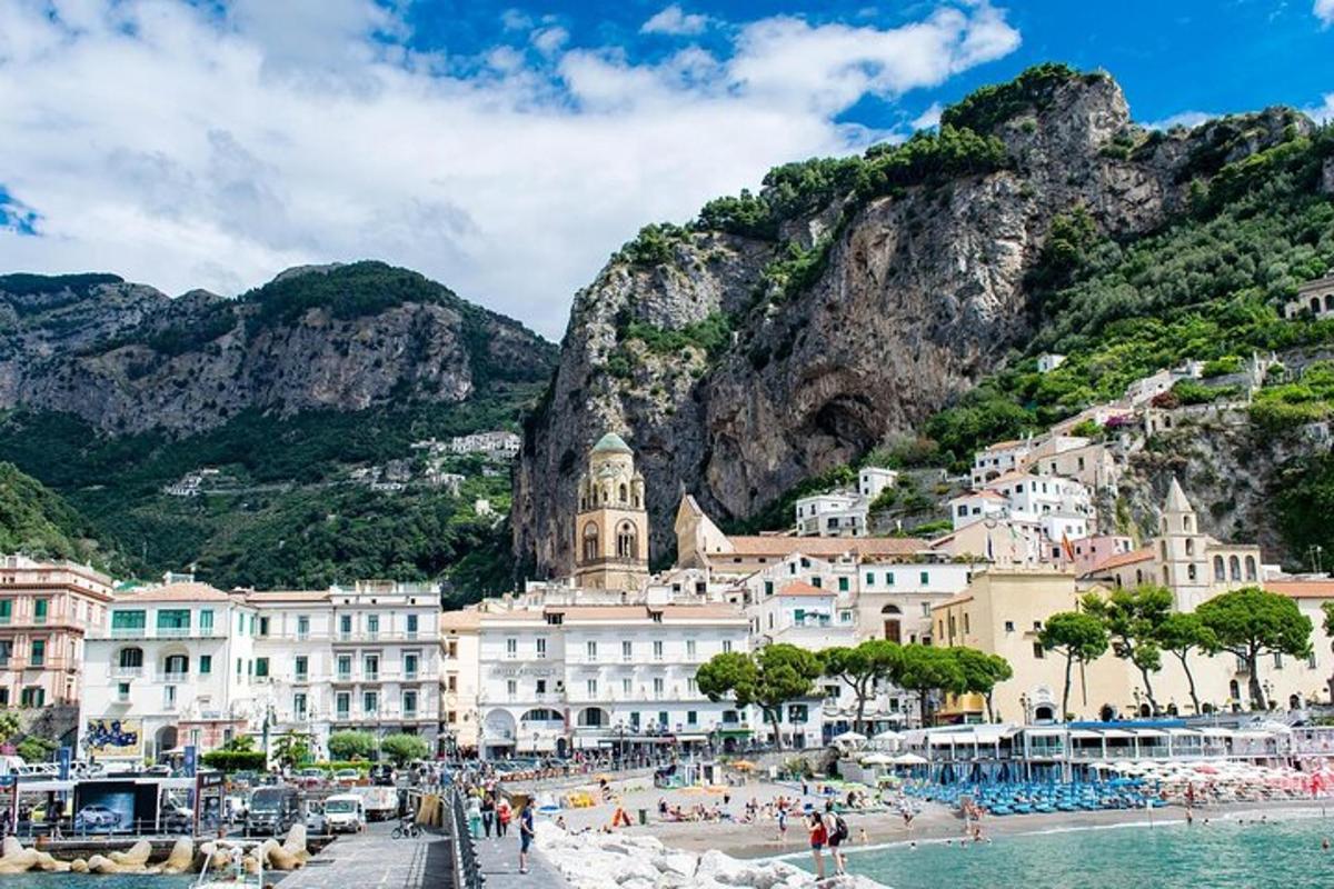 a group of buildings on a beach next to a mountain