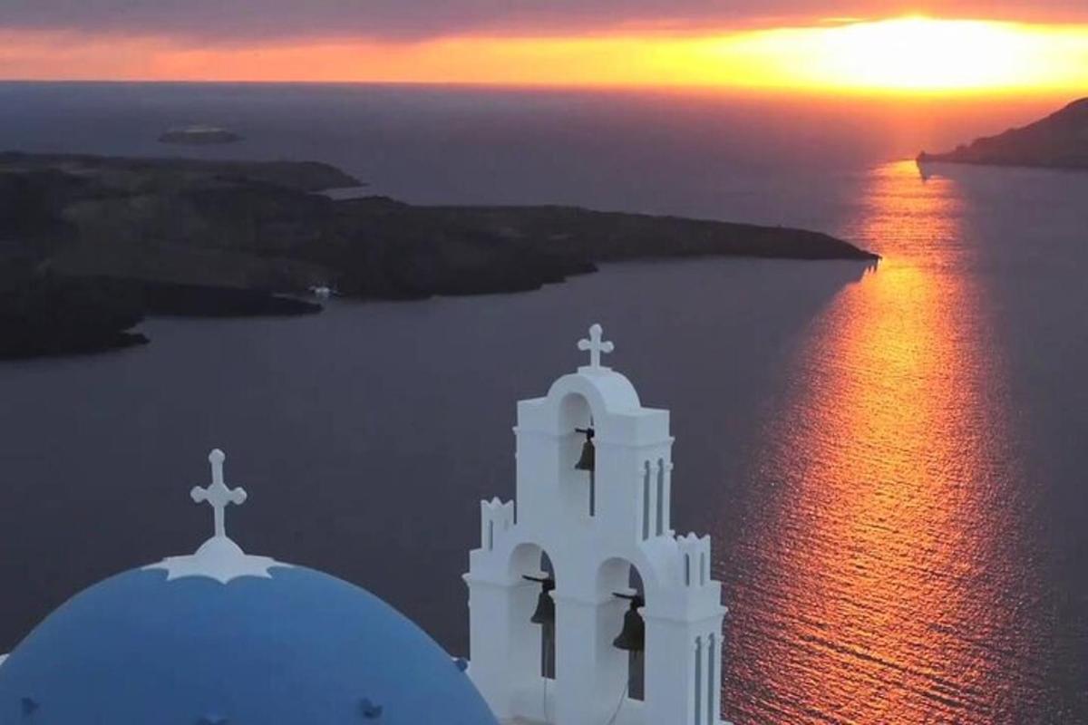 una chiesa bianca con un tramonto sullo sfondo