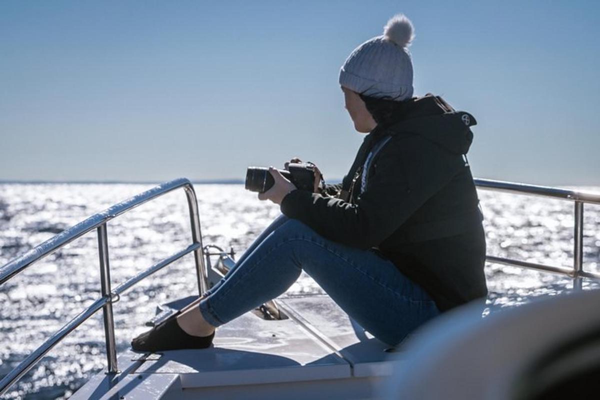 una donna seduta su una barca con una macchina fotografica