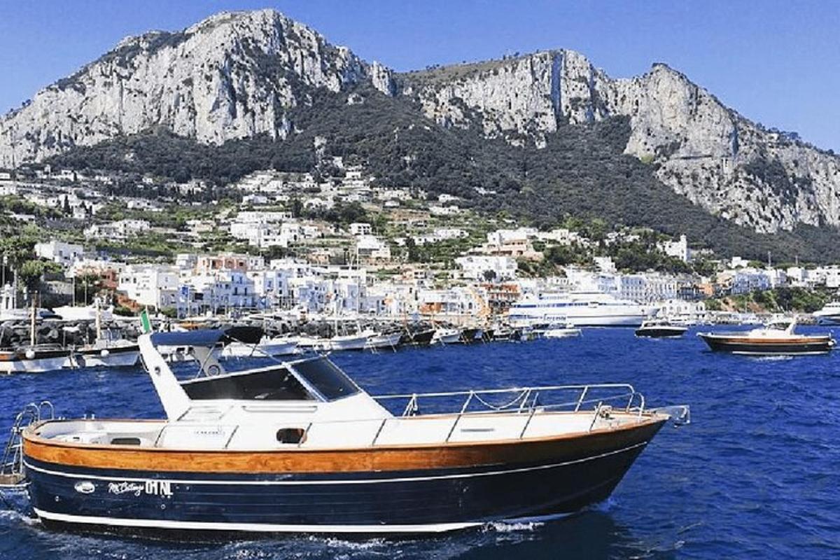 μια βάρκα στο νερό με ένα βουνό στο φόντο