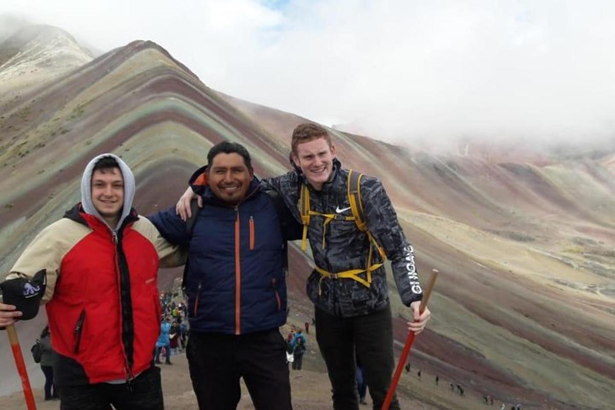 un gruppo di tre uomini in piedi di fronte a una montagna