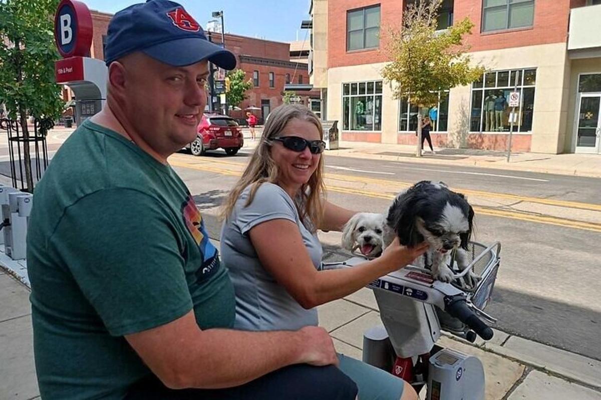 un uomo e una donna in moto con due cani