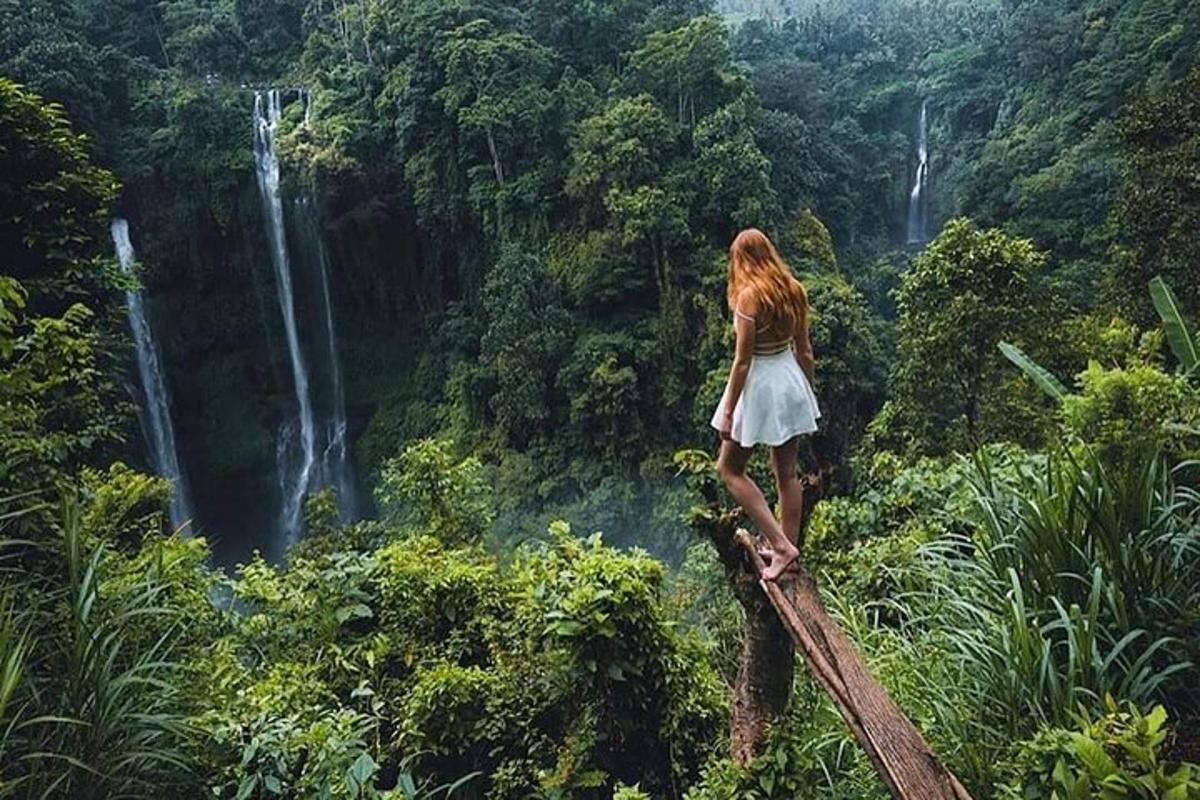 seorang wanita berdiri di atas jambatan kayu di dalam hutan