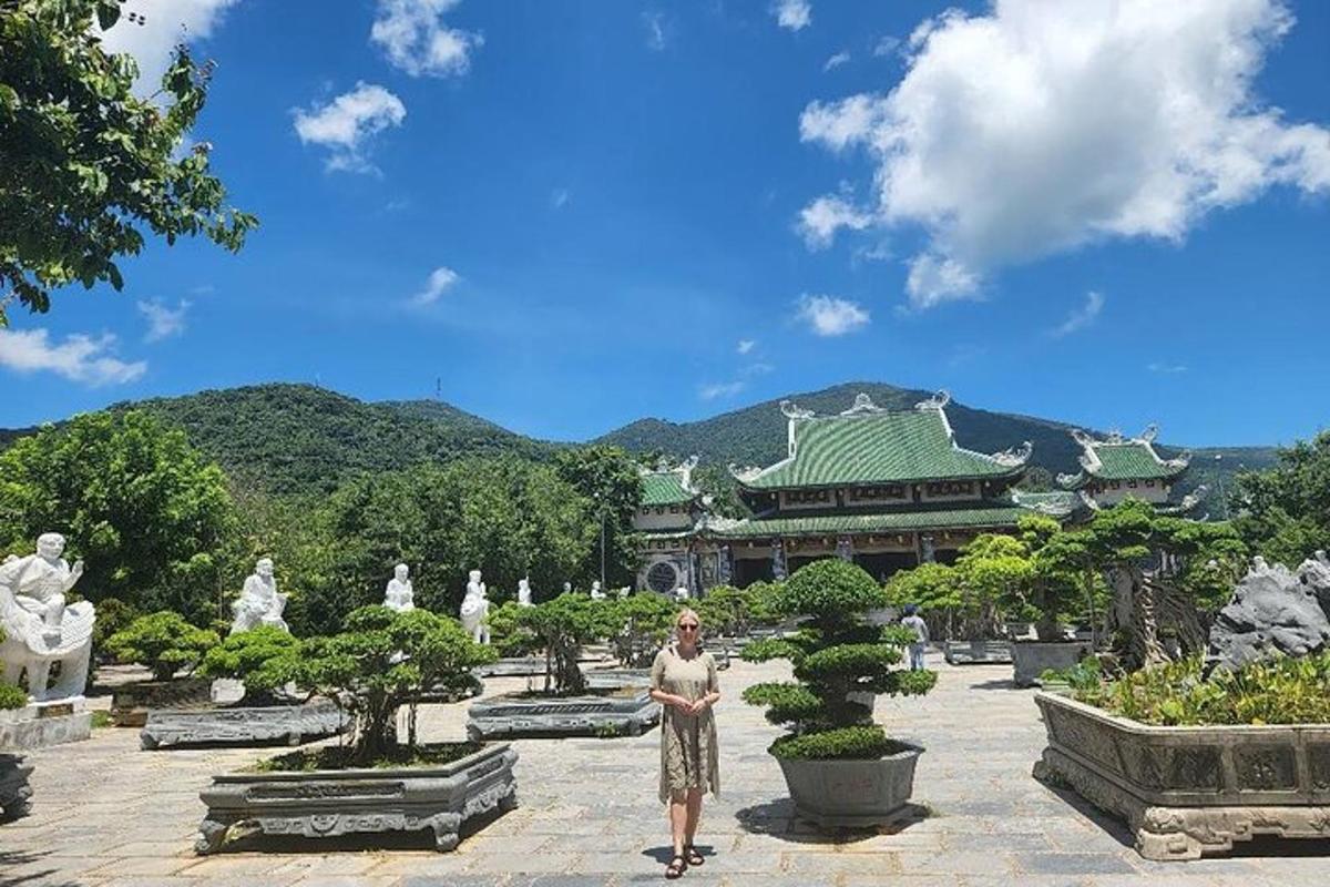 uma mulher em pé em frente a um jardim com árvores bonsai