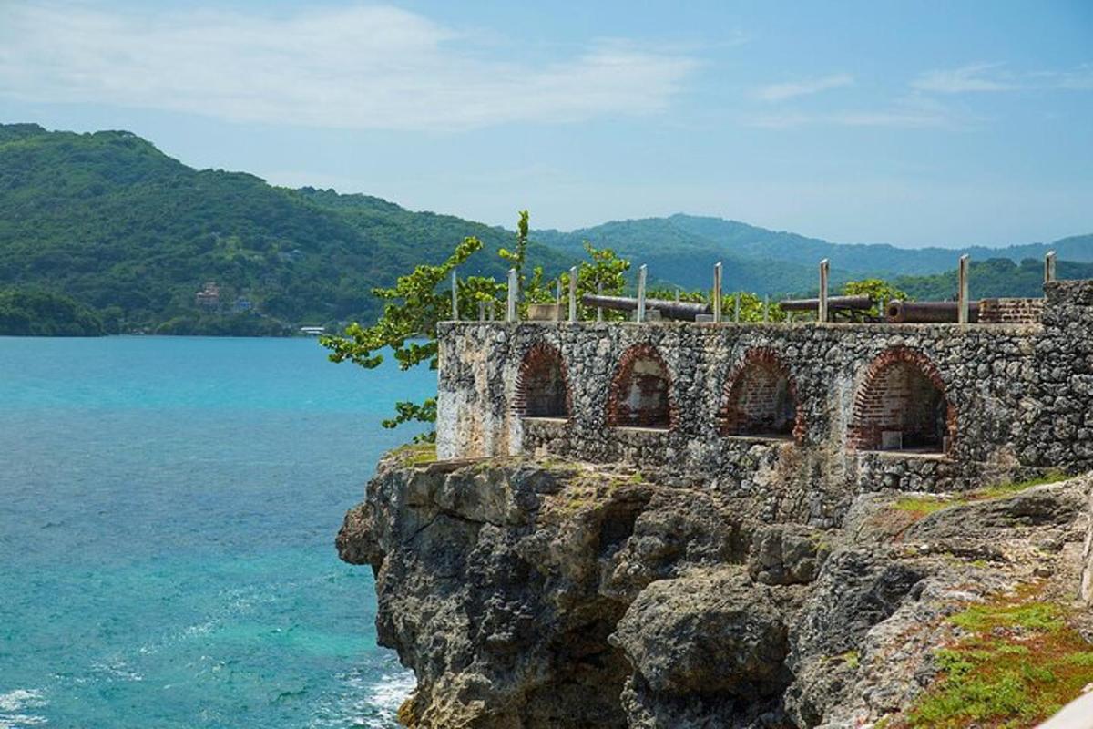 un edificio in pietra su una scogliera vicino all'acqua