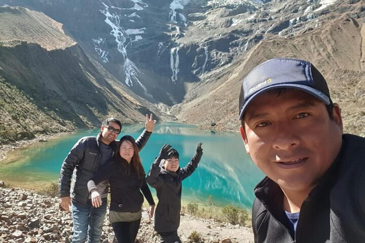 um grupo de pessoas em pé em frente a um lago