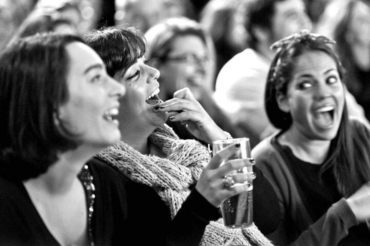 un gruppo di persone sedute in mezzo alla folla con dei drink