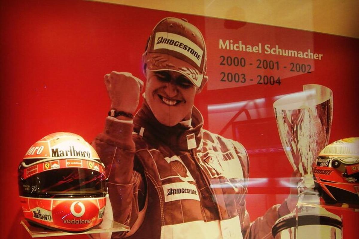 a man is holding up a winners helmet and a trophy