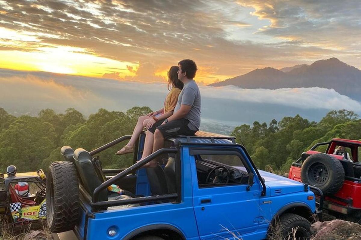 two people sitting on the back of a jeep