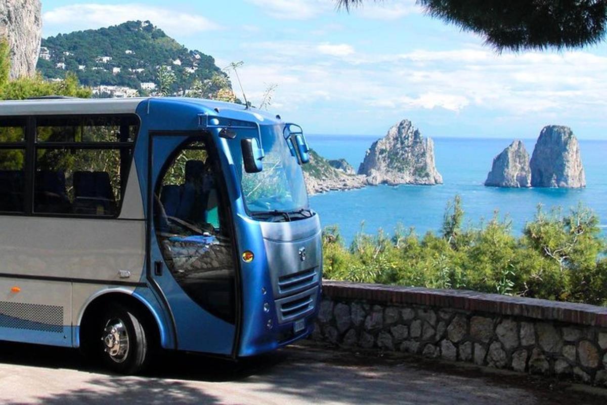 Un autobús azul y blanco estacionado junto al océano.