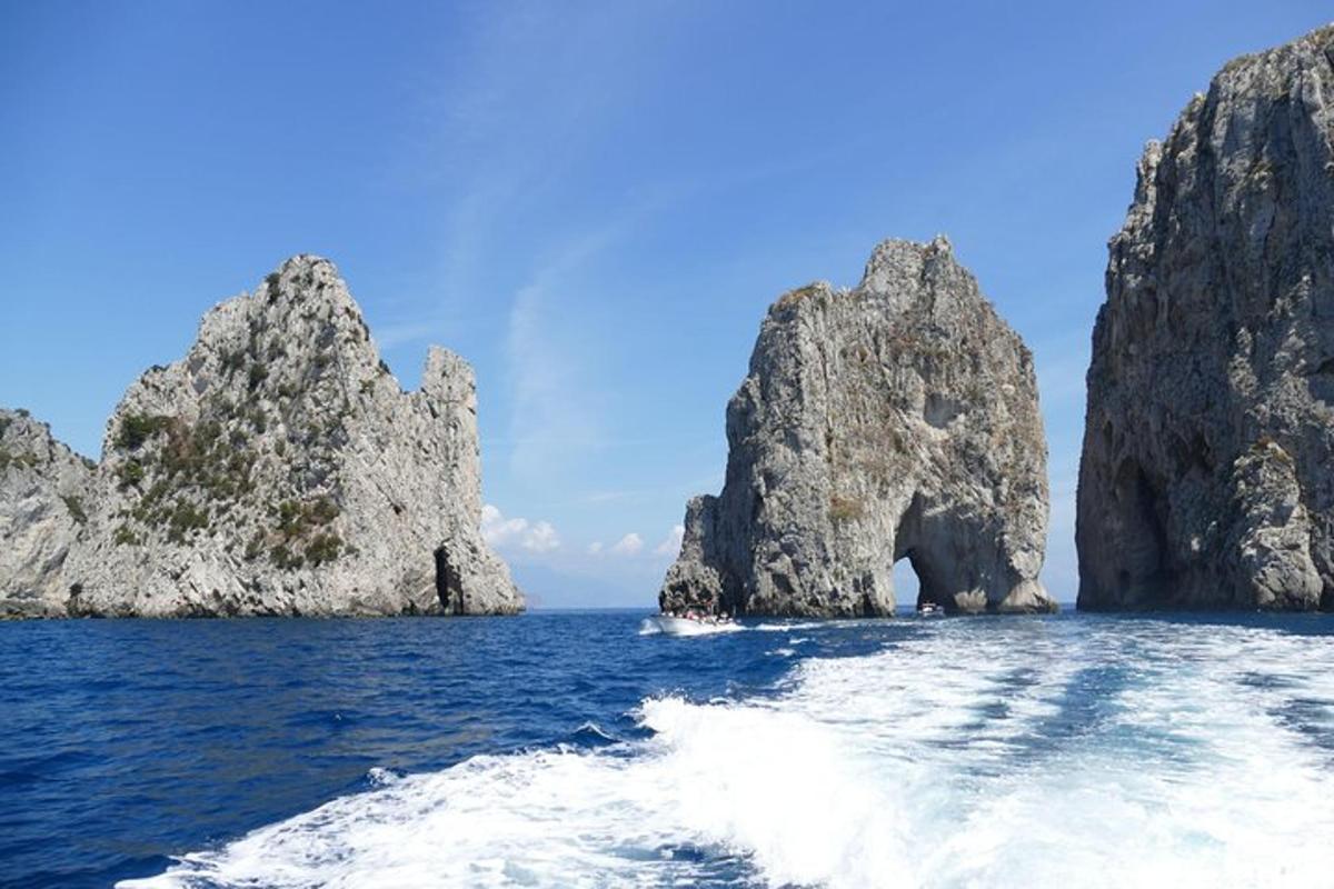 лодка в океане со скалами в воде