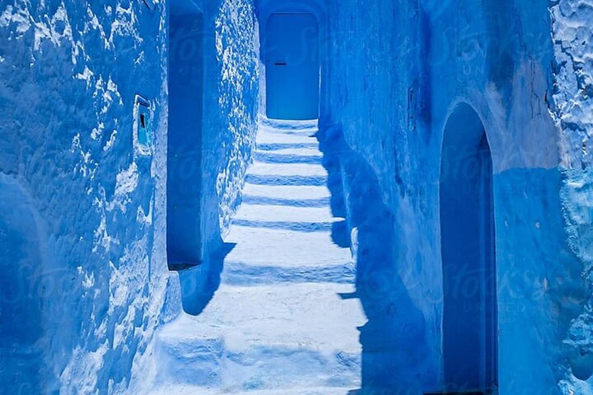 um beco em um prédio azul com neve